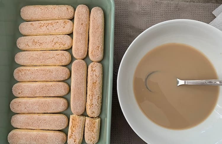 1. Začneme prípravou kávy, ktorú necháme vychladnúť. Do nej vlejeme likér podľa preferencie a dôkladne zamiešame. Obe ingrediencie sú voliteľné, takže pokojne môžeme tento krok aj vynechať. Následne dlhé piškóty naukladáme na dno formy tak, aby sme pokryli celú jej plochu. Studenou kávou polejeme, avšak veľmi opatrne. Stačí cca 4-5 PL. Fotka - Andrea