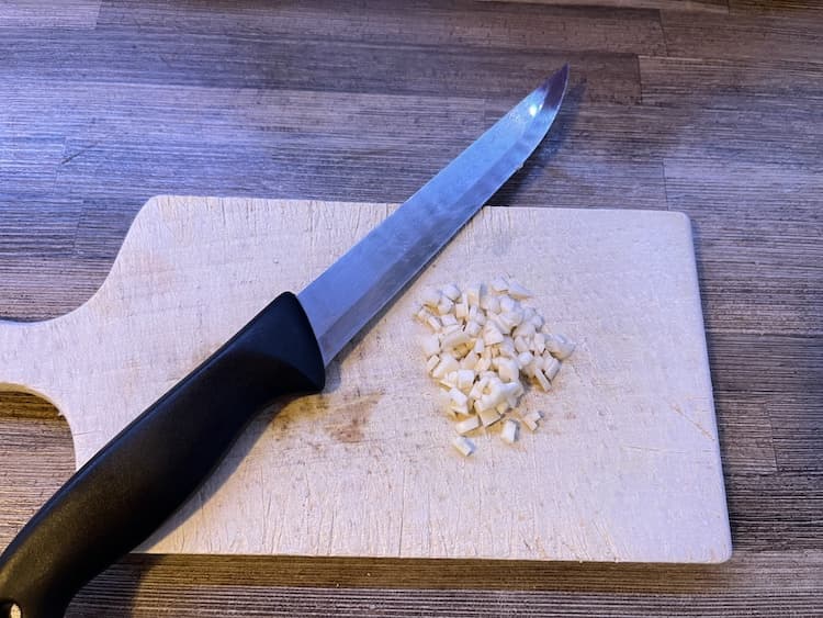 3. Následne si nadrobno nakrájame strúčik cesnaku. Kúsky prihodíme k syrovej zmesi v miske. Fotka - Zuzana Zsilleová