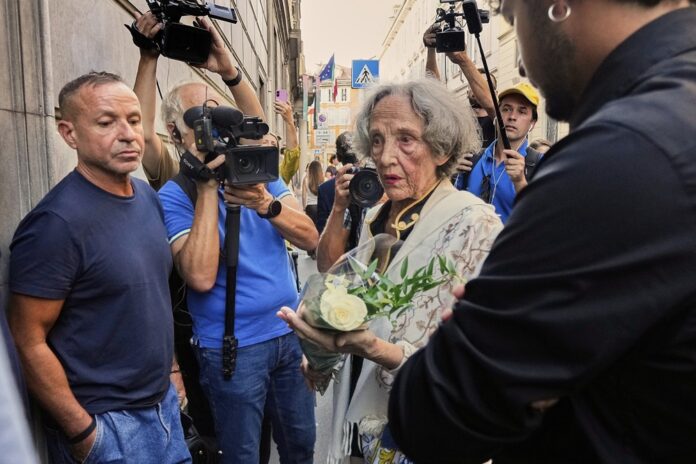 Žena prináša kvety k domu svetoznámeho talianskeho odevného návrhára Giorgia Armaniho, ktorý zomrel vo veku 91 rokov v Miláne 4. septembra 2025. Foto - TASR/AP